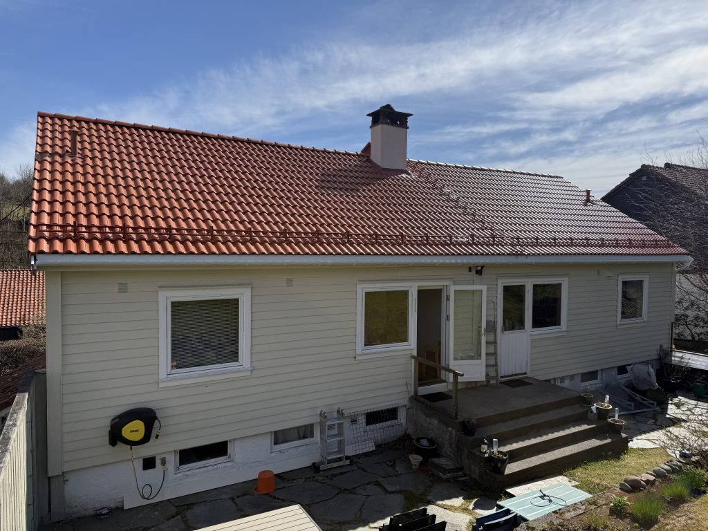 Bildet viser bolig Nattlandsåsen 11, som har fått nytt tak med teglrød betongtakstein.